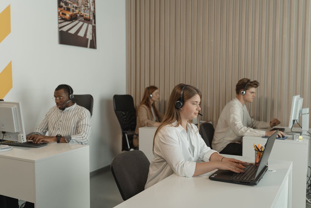 Office scene with call center employees at work, focusing on teamwork and productivity.