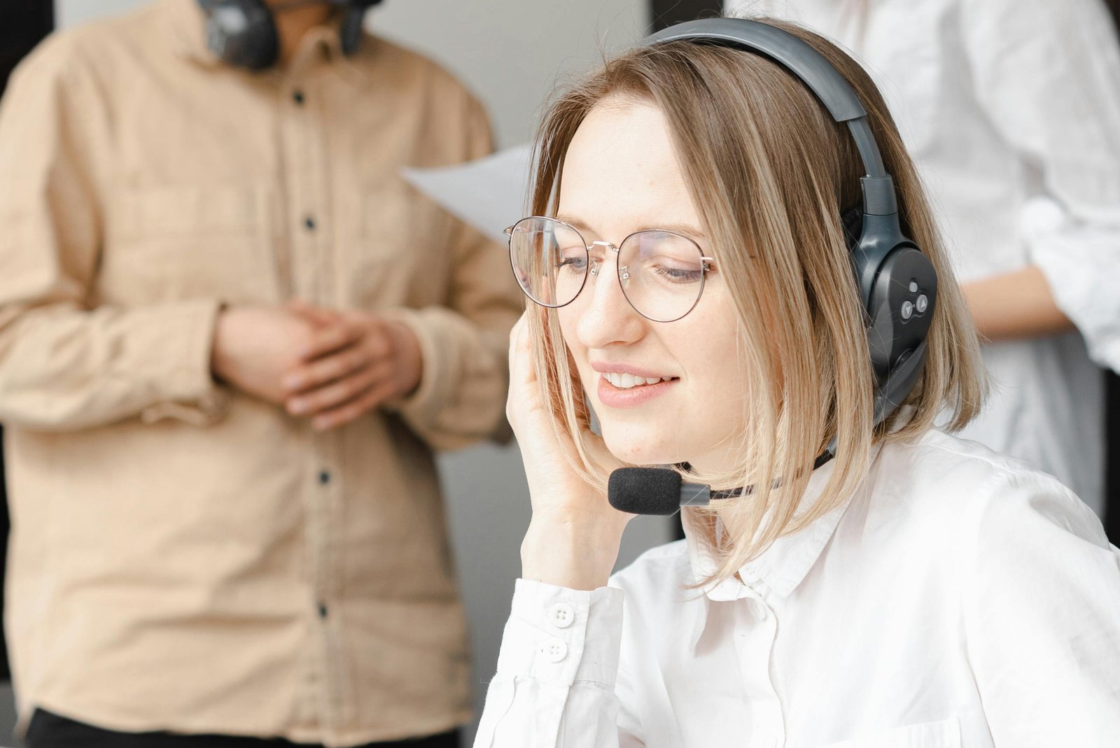 Professional woman providing customer support with a headset in an office setting.